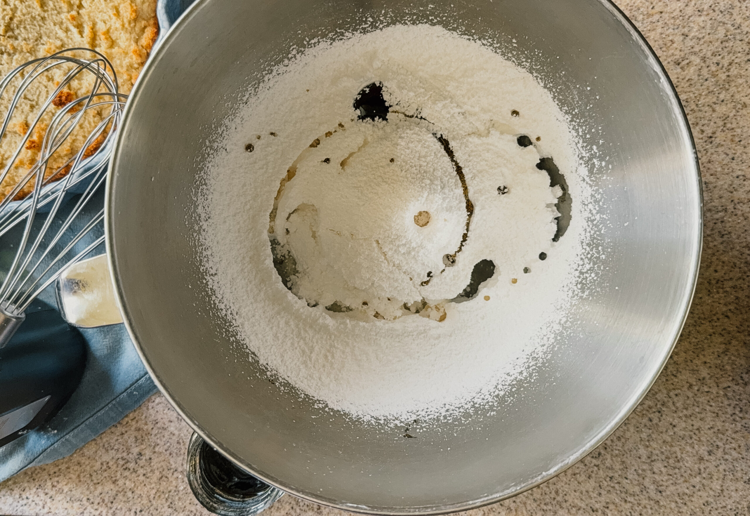 Frosting ingredients in a mixer bowl about to be whipped.