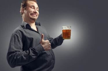 Drunk guy with a thumbs up and a beer.