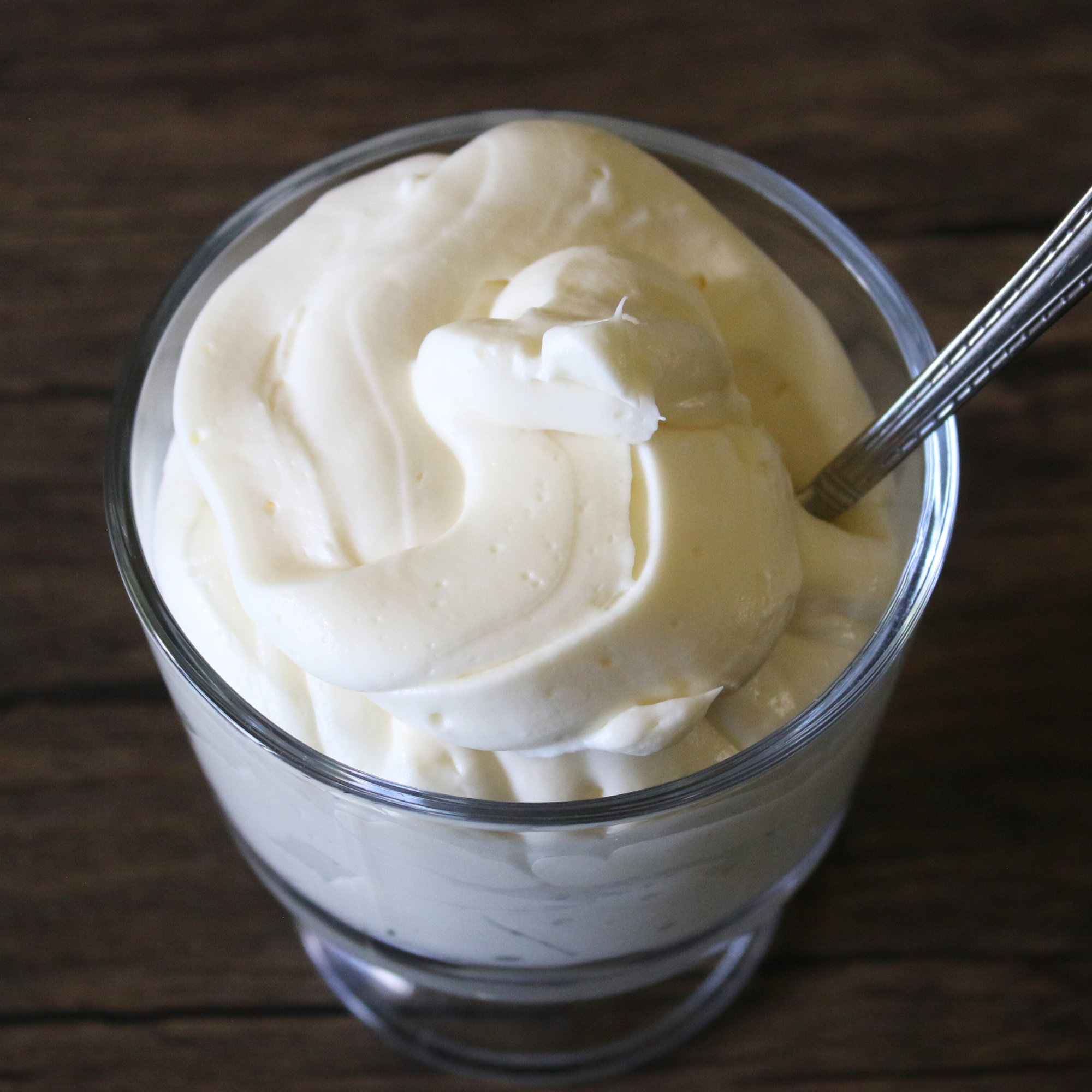 A bowl of creamy cheesecake fluff on a wooden countertop.