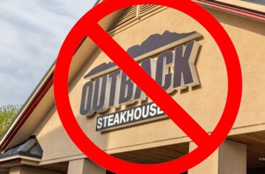 Outback Steakhouse sign with a red prohibition symbol over it.