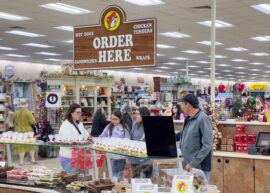 "Order here" sign in a Buc-ee's with people standing under it