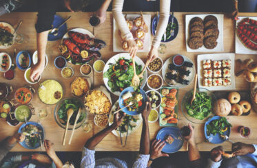 Brunch dishes and arms as seen from above
