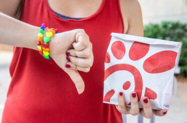 Woman giving a thumbs down to a Chick-fil-A sandwich