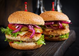 Two burgers with spears in the tops