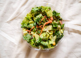 A bowl of mixed green salad with various vegetables.