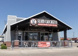 Front view of Slim Chickens restaurant with signage and outdoor seating.