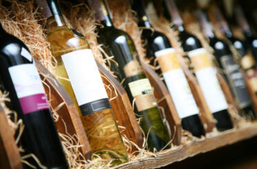 Various wine bottles arranged in wooden racks with straw.