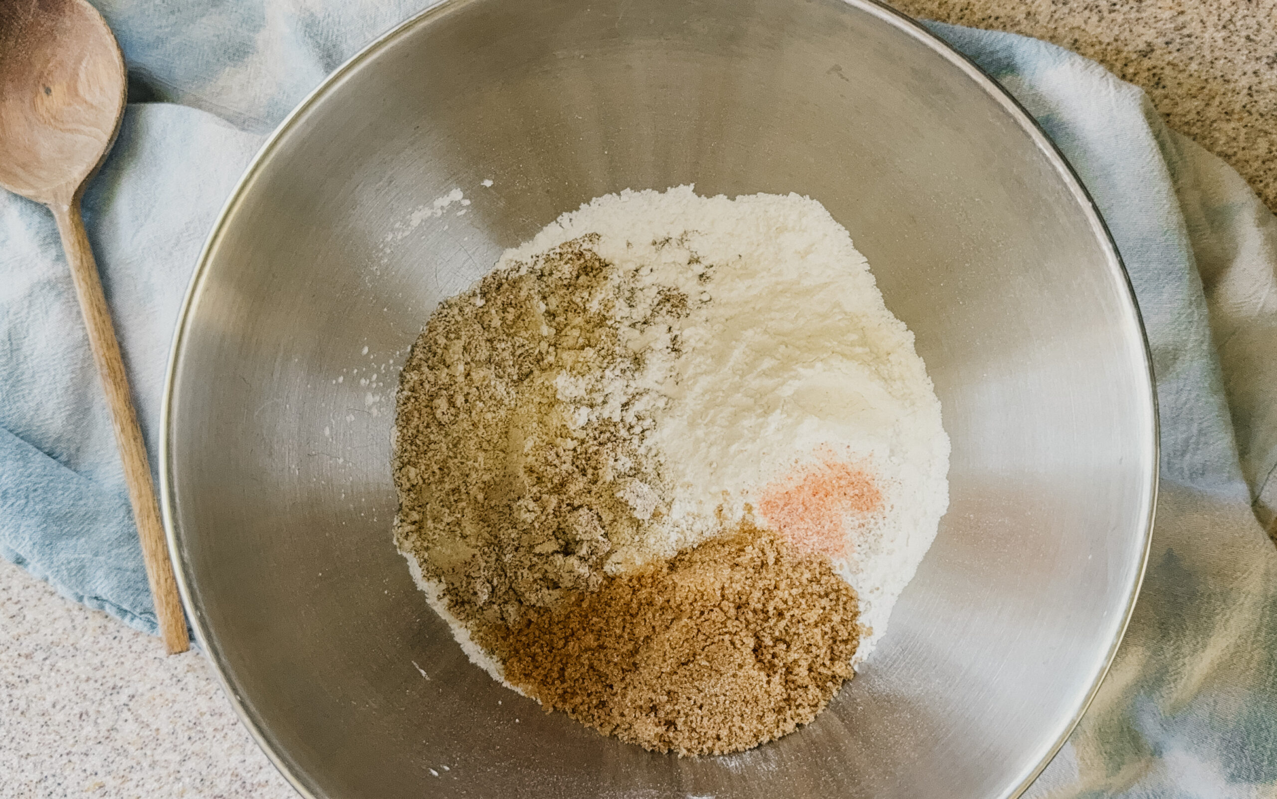 A silver bowl with dry ingredients about to be mixed.