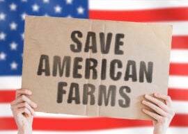 The phrase " Save American farms " on a banner in men's hand with blurred American flag on the background. Agriculture business.