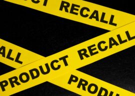 Product recall alert, caution and warning concept. Yellow barricade tape with word in dark black background