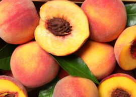 View of whole and cut peaches exposing pit