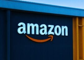 Close up view of an Amazon sign and corporate Amazon logo on an Amazon warehouse