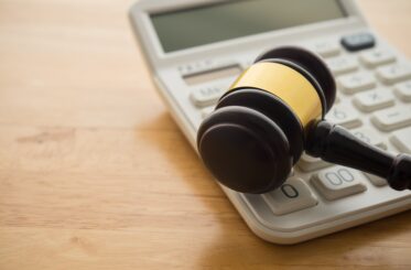 Judge's gavel next to a calculator