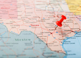 Red clerical needle on a map of USA, Texas and the capital Austin. Closeup Map Texas with Red Tack