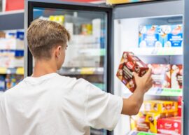 Man choosing frozen food from a supermarket freezer.