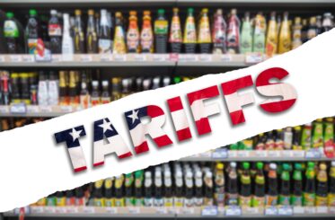 A grocery isle with a bold overlaid text reading "Tariffs" in American flag colors.