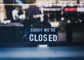 Moody image capturing a 'Sorry We're Closed' sign in a London shop window.