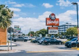 Wendy's parking area crowded with cars under a clear blue sky in Orlando.